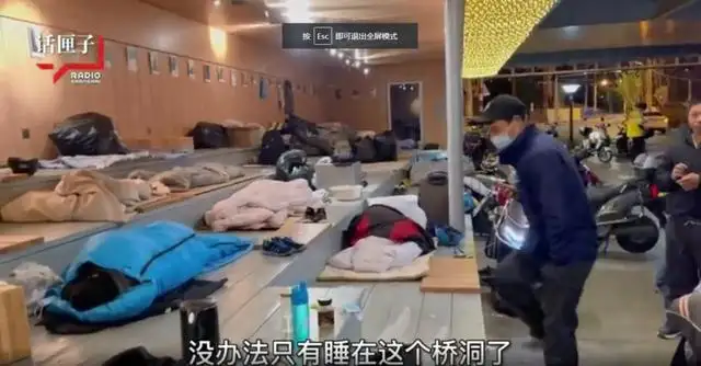一名外卖小哥竟盖着被子和送外卖时穿的冲锋衣，睡在自己的电动车上