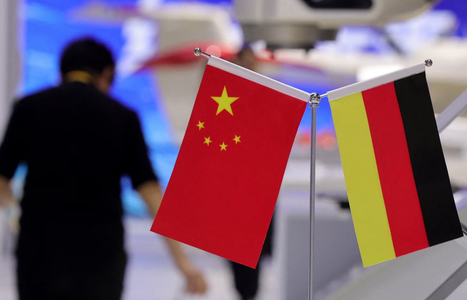 在中国上海举行的第八届中国国际进口博览会（进博会）上，一名行人走过中国国旗和德国国旗 ...