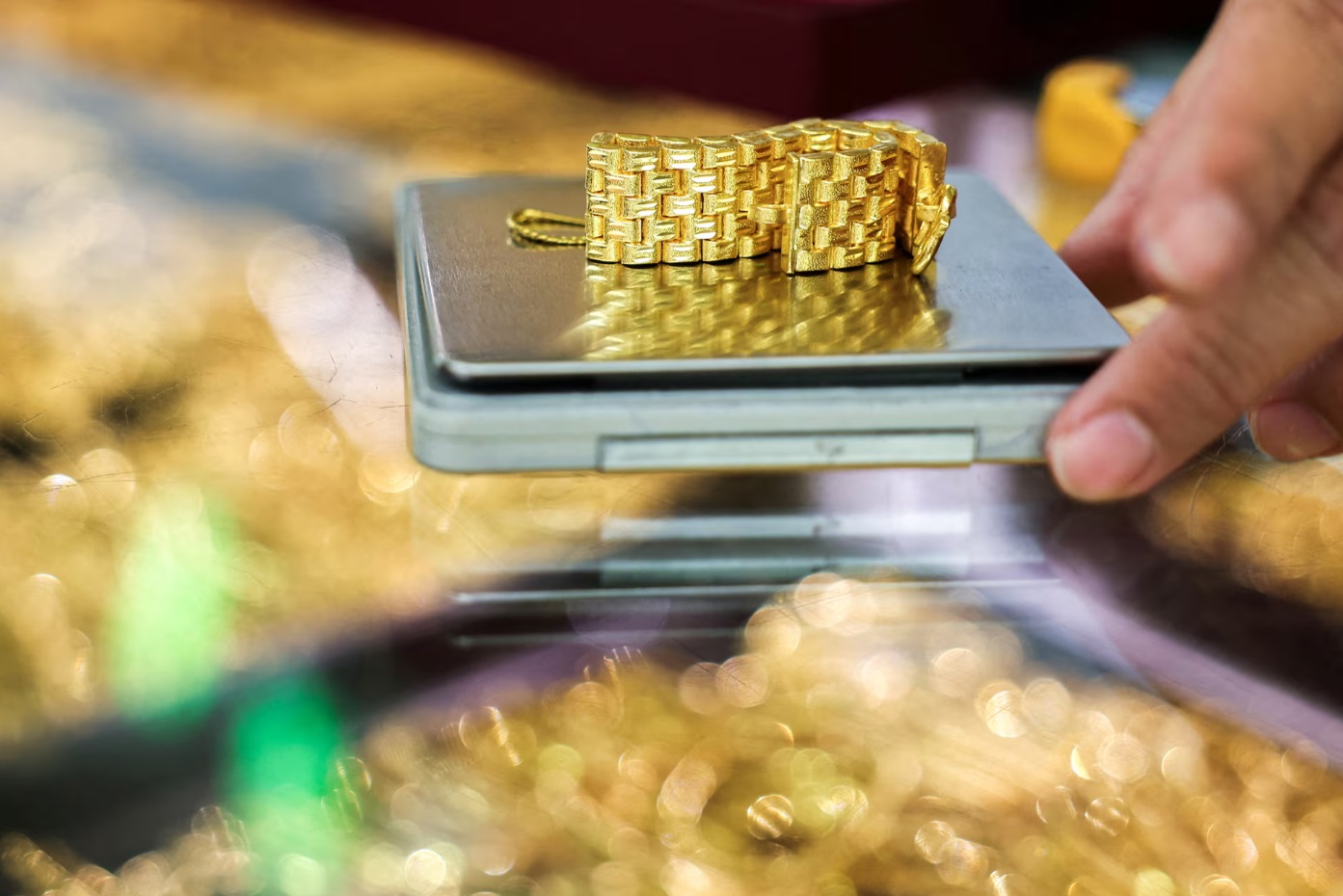 在泰国曼谷一家金店里，一名黄金卖家正在称量一条金表链。当天，金价飙升，创下历史新高 ... ... ...