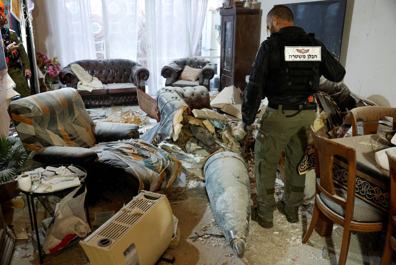  2026年3月20日，在以色列雷霍沃特，一名以色列警察在客厅里检查伊朗导弹的一部分 ...